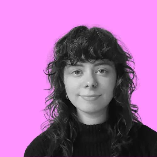 Porträt von Alma Bartels, einer jungen Frau mit lockigem Haar und Nasenpiercing vor pinkem Hintergrund.