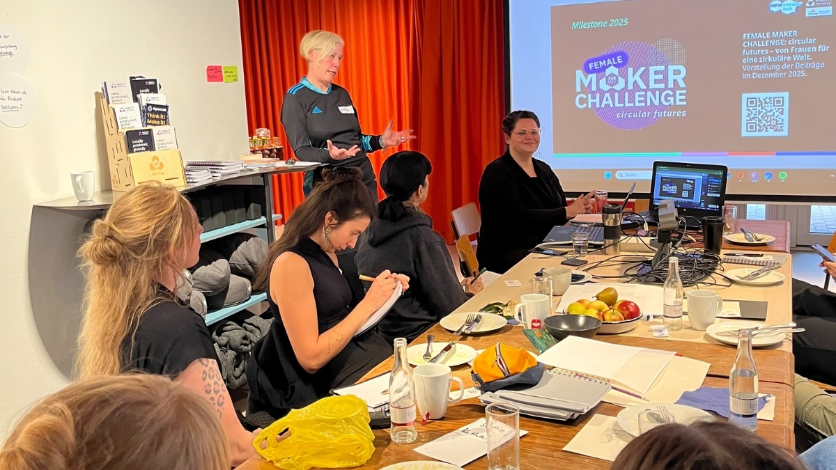 Eine Gruppe von Frauen nimmt an einem Workshop der Female Maker Challenge teil, bei dem eine Referentin spricht und die Projektziele für 2025 vorgestellt werden